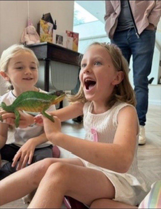 A girl delighted to hold a chameleon